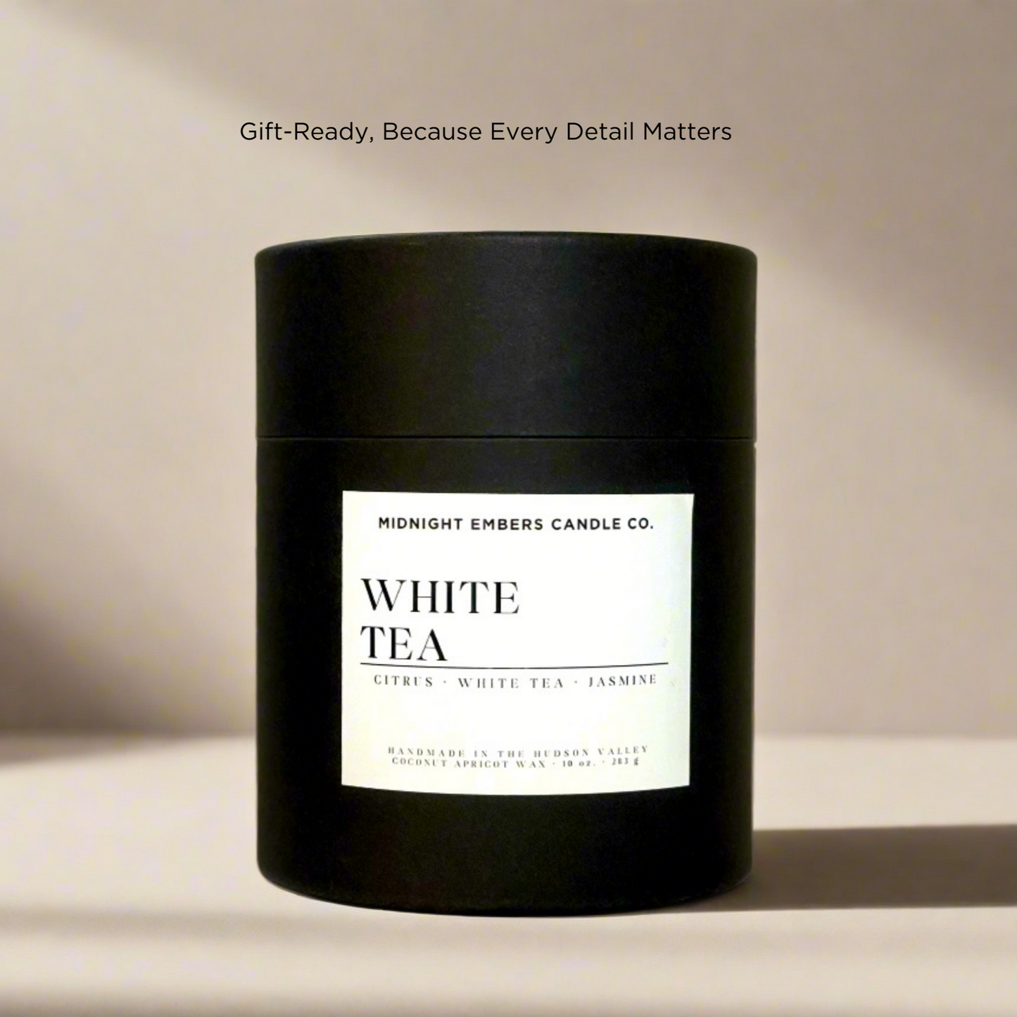 Black candle gift box with a white label on a beige background
