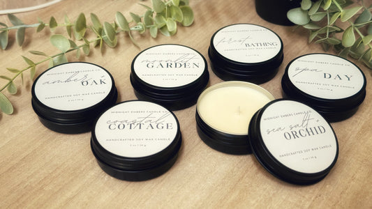 A collection of mini soy candles with labeled lids, each with a different fragrance name including Oak, Garden, Day, Orchid, and Sea.