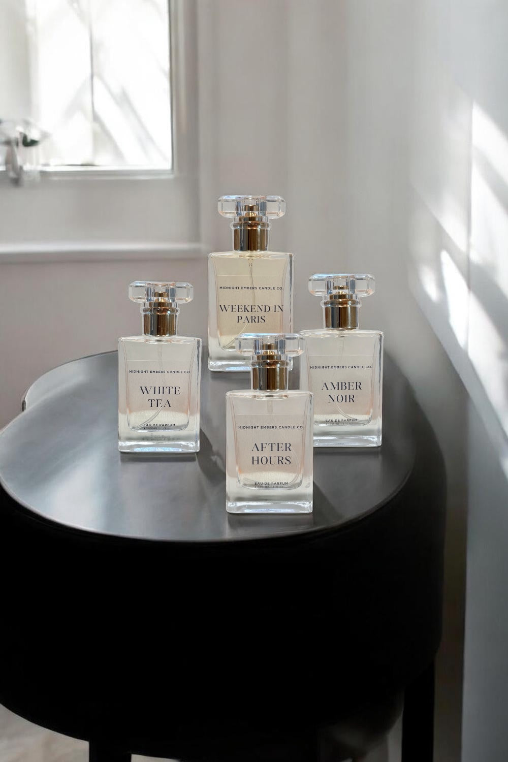 Four perfume bottles on a black round table with a neutral background