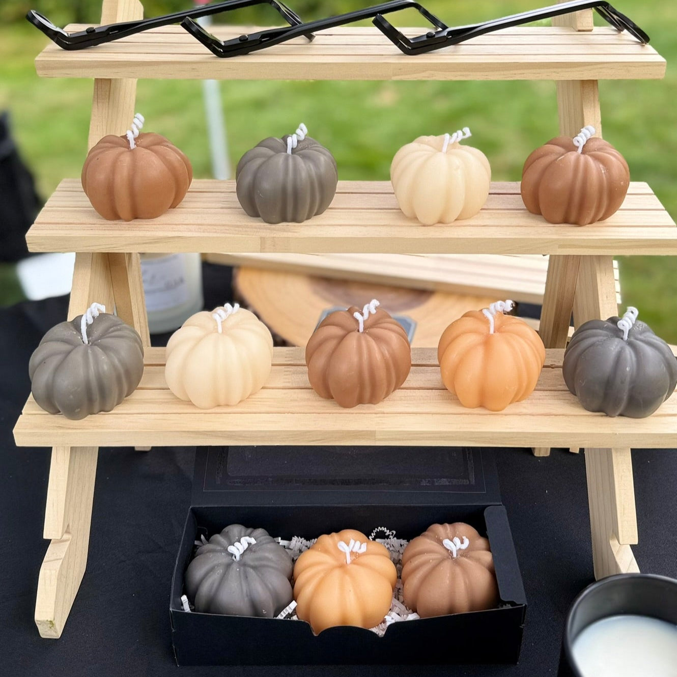 Wooden display stand with small pumpkin candles.