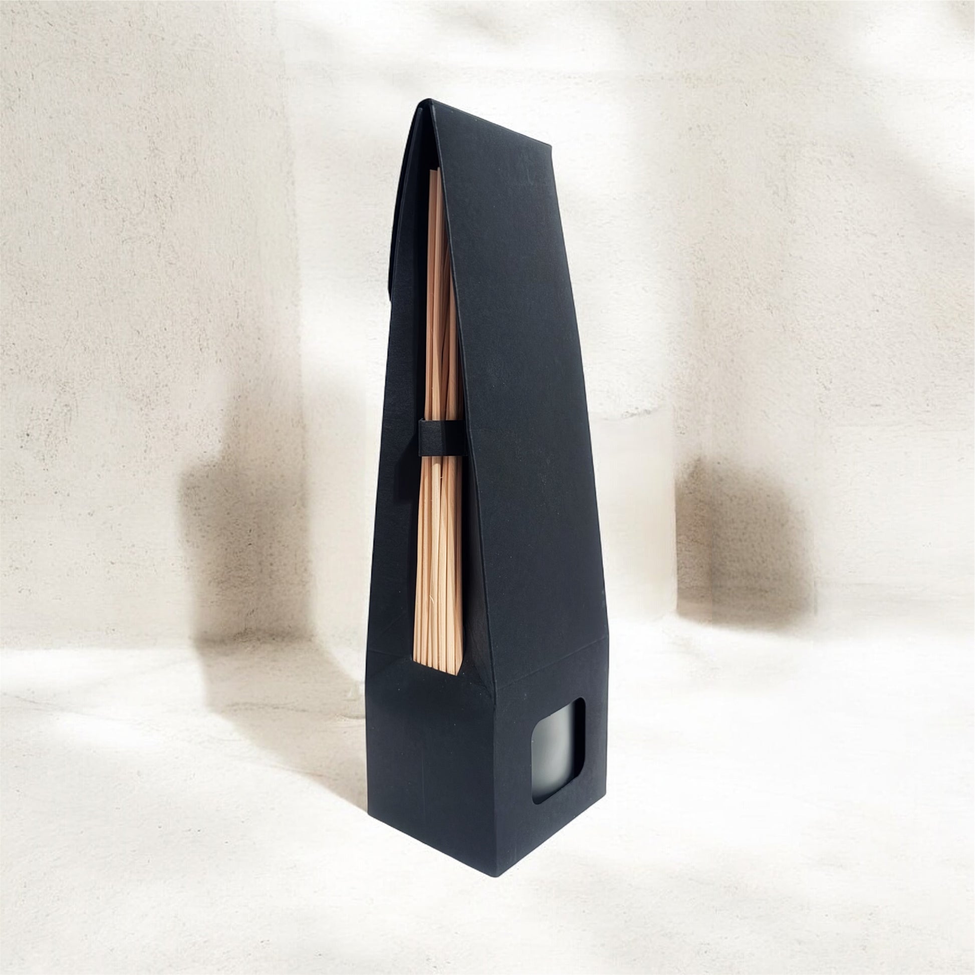 Black wall-mounted shelf with a wooden rod on a white background