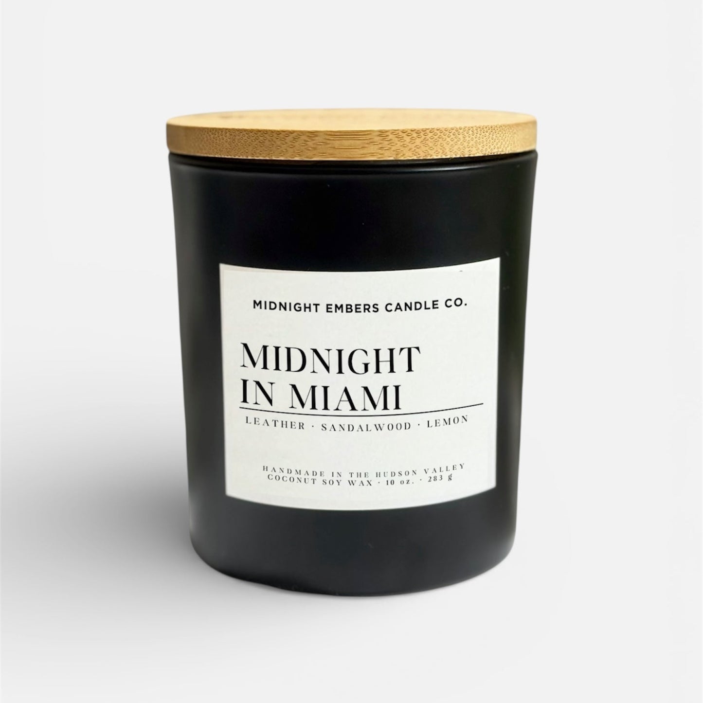 Black candle with a wooden lid labeled 'Midnight in Miami' on a white background