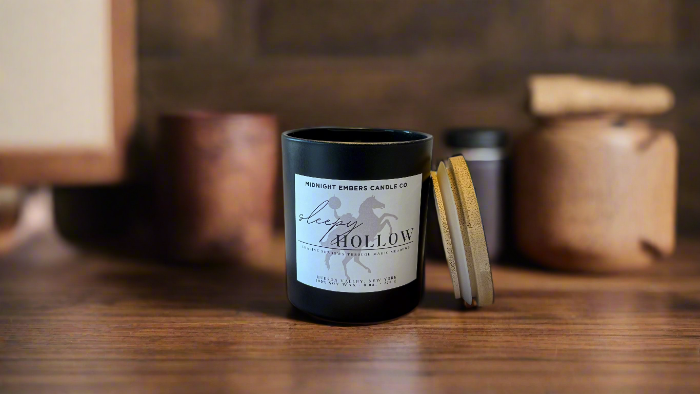 A matte black jar with a bamboo lid labeled 'Sleepy Hollow', placed on a wooden surface with a woodcut background.