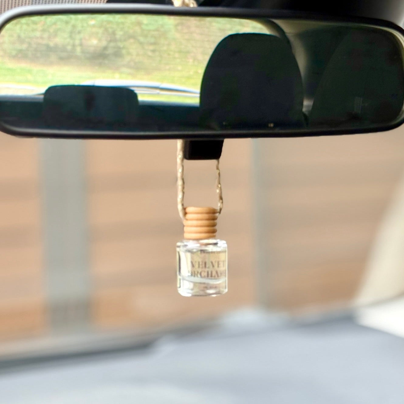 Car air freshener hanging from a mirror in a vehicle
