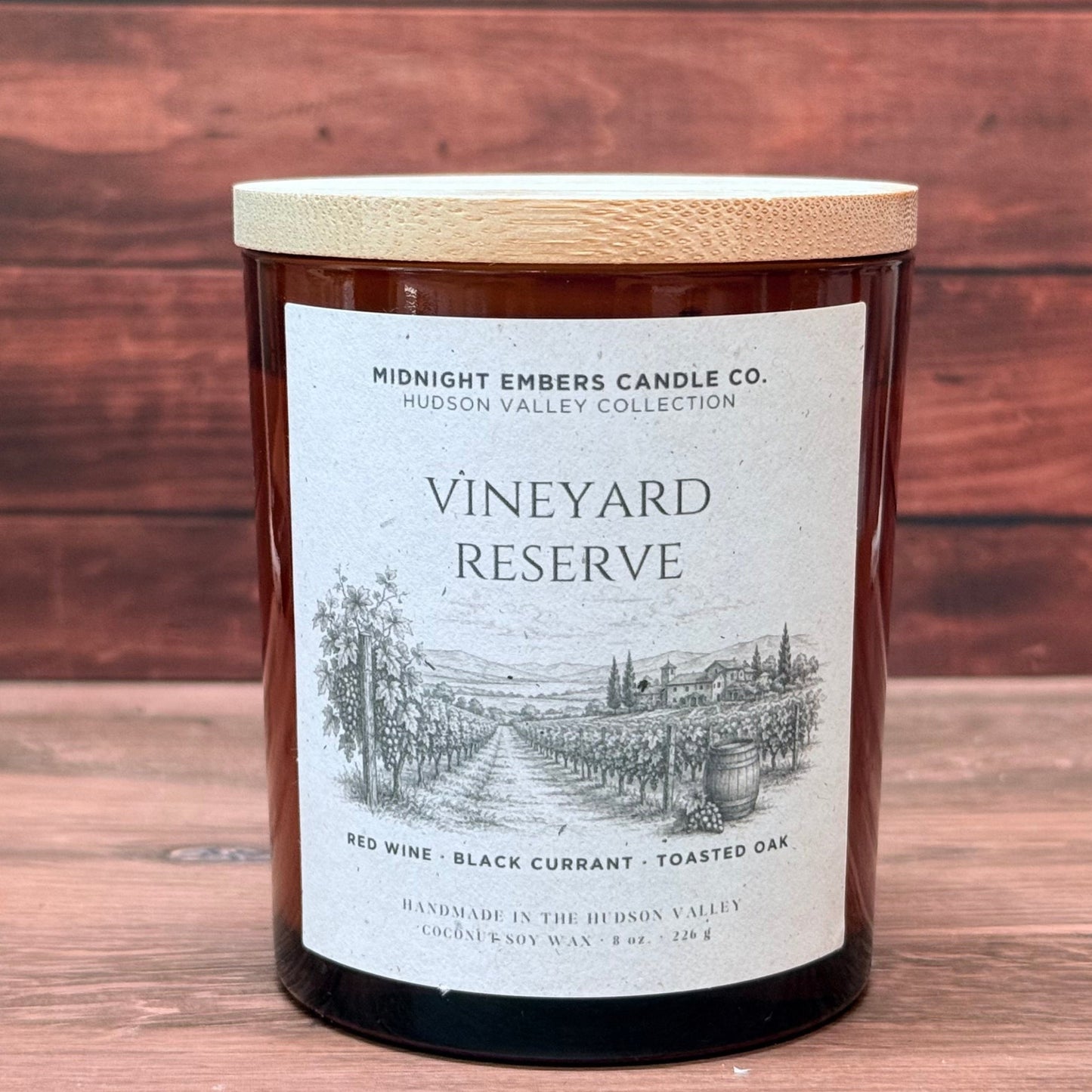 Candle labeled 'Vineyard Reserve' from Midnight Embers Candle Co. on a wooden background
