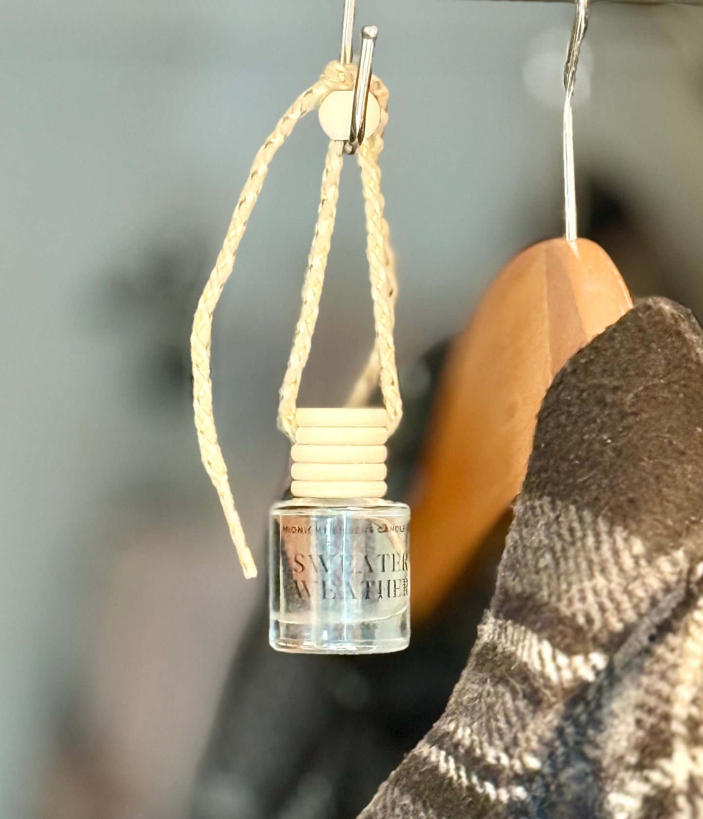 Small glass bottle with natural rope on a hanger in a coat closet