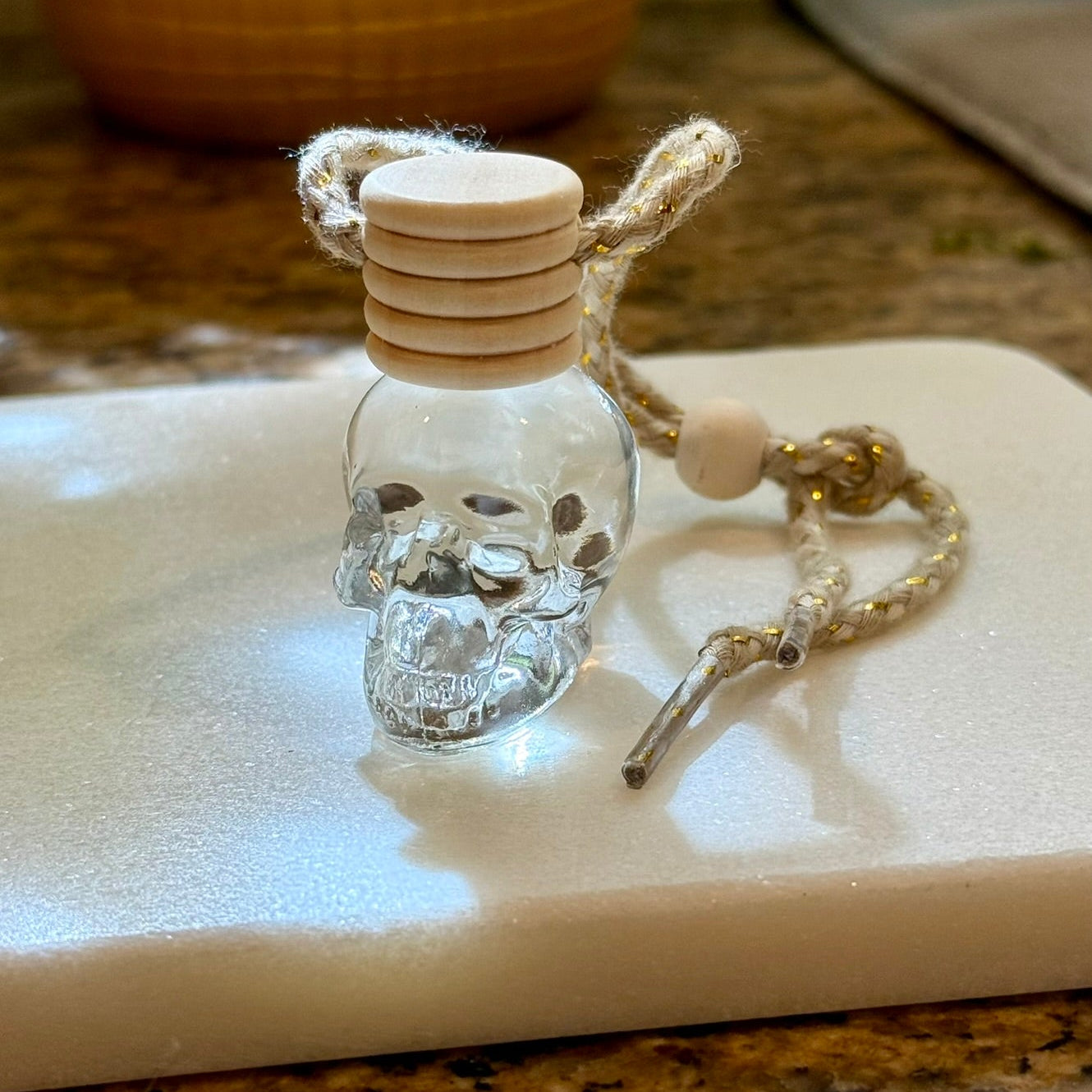 Small glass bottle with a skull design on a white surface